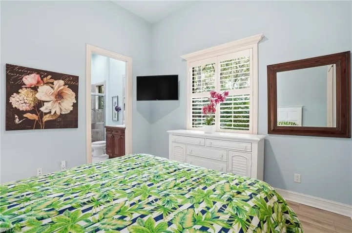 Bedroom with connected bathroom and light wood-type flooring