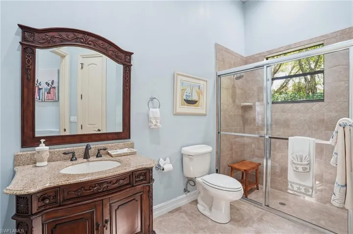 Full bath with vanity, a stall shower, and light tile patterned flooring