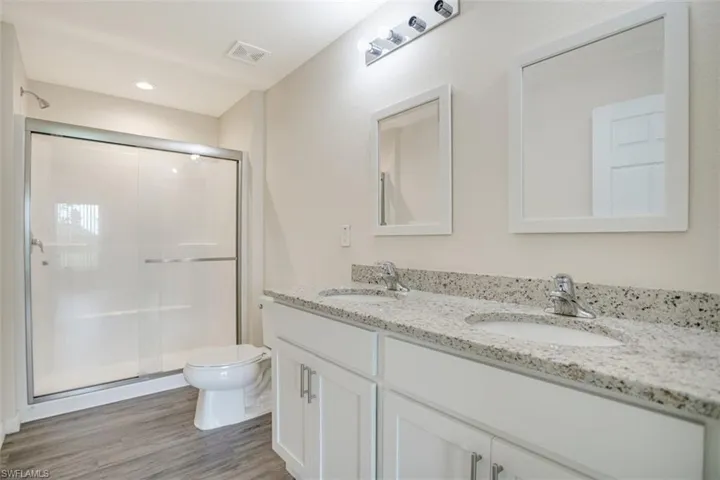 Ensuite Bathroom with double vanity, shower with glass door