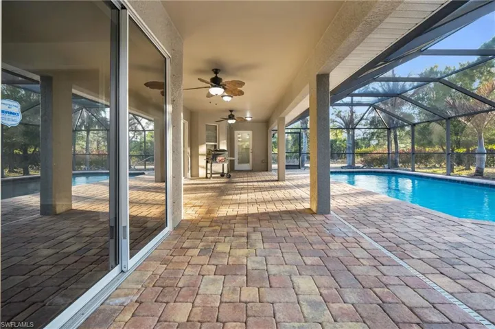 Swimming pool with a lanai, a sunroom, and a patio
