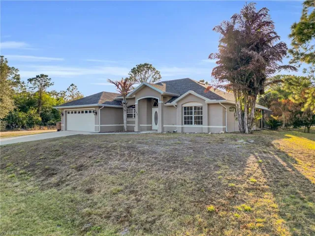 Ranch-style home featuring stucco siding, concrete driveway, a garage, and a front lawn
