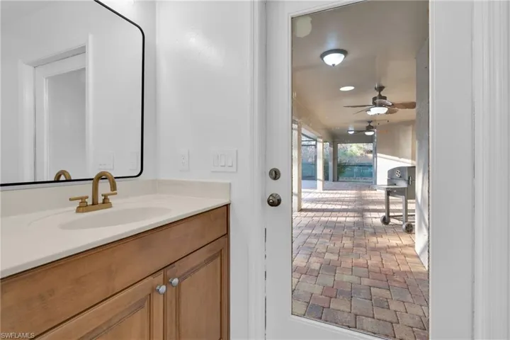 Bathroom featuring vanity, a ceiling fan, and brick patterned floors