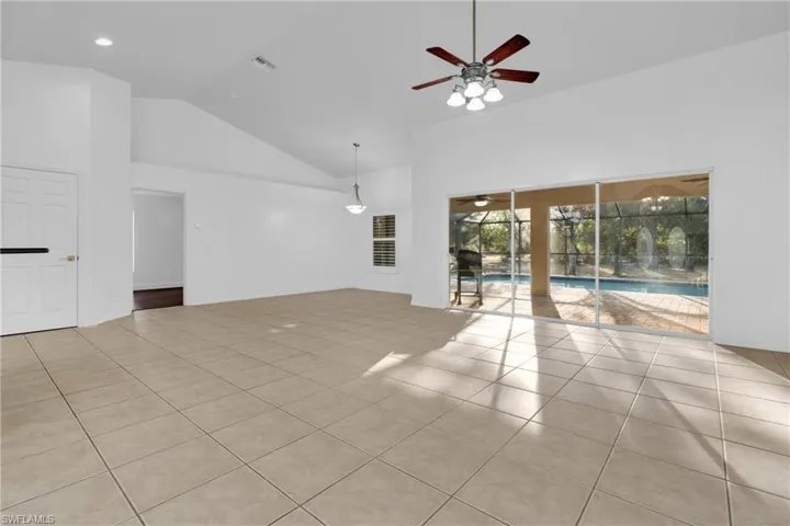 Spare room with light tile patterned floors, vaulted ceiling, a ceiling fan, and a sunroom