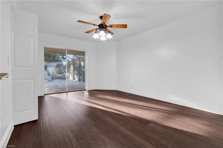 Unfurnished room with dark wood-style flooring and ceiling fan