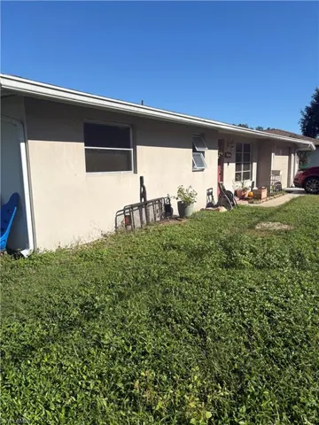 Stucco exterior featuring horizontal sliding windows and a concrete driveway