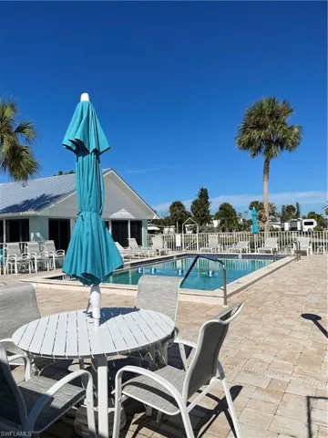Community pool with a patio area and outdoor dining area