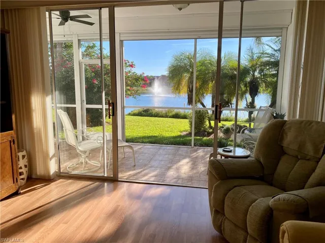 Doorway featuring ceiling fan, a water view, and hardwood / wood-style flooring