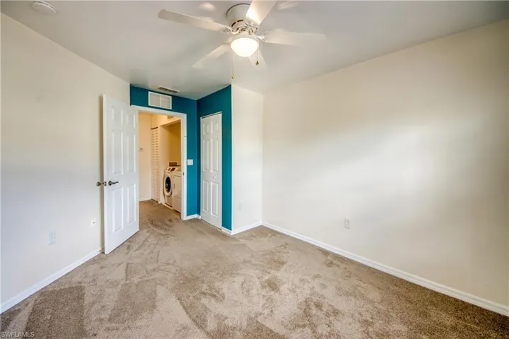 Unfurnished bedroom with ceiling fan, a closet, carpet flooring, and washer / dryer