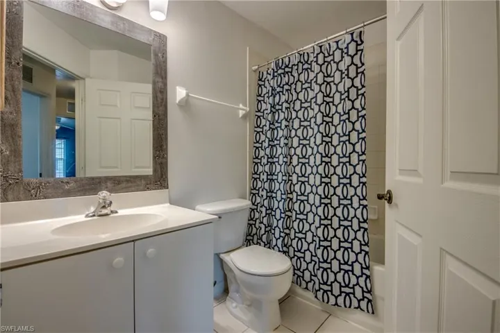 Full bathroom featuring vanity, toilet, tile floors, and shower / tub combo