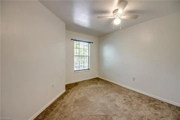 Spare room featuring carpet and ceiling fan