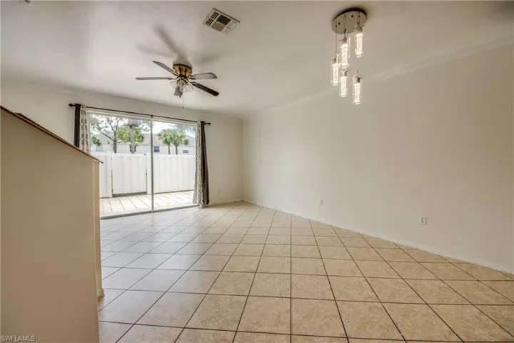 Unfurnished room featuring ceiling fan, light tile flooring, and ornamental molding