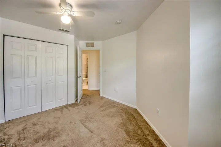 Unfurnished bedroom featuring a closet, carpet floors, and ceiling fan
