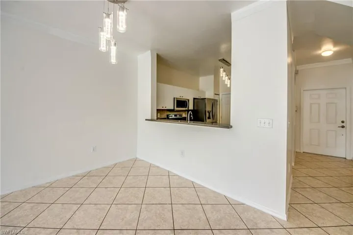 Unfurnished room with sink, ornamental molding, and light tile floors