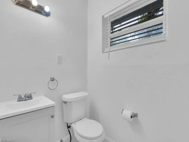 Half bathroom featuring vanity and toilet
