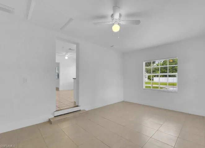 Unfurnished room with a ceiling fan and light tile patterned floors