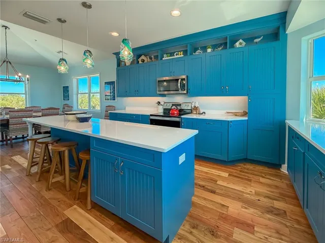 Kitchen with blue cabinets, visible vents, appliances with stainless steel finishes, and a kitchen island