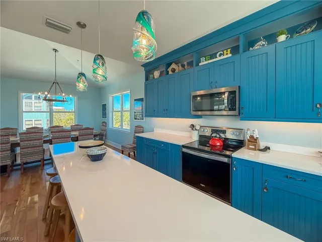 Kitchen featuring light countertops, blue cabinetry, visible vents, and appliances with stainless steel finishes
