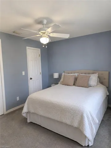 Guest suite with walk-in closet and ceiling fan.