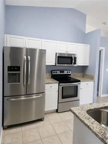 Updated kitchen featuring stainless steel appliances, granite countertops, and ample cabinet space.