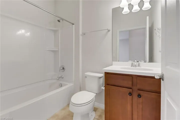 Bathroom featuring vanity, tile patterned floors, and shower / washtub combination