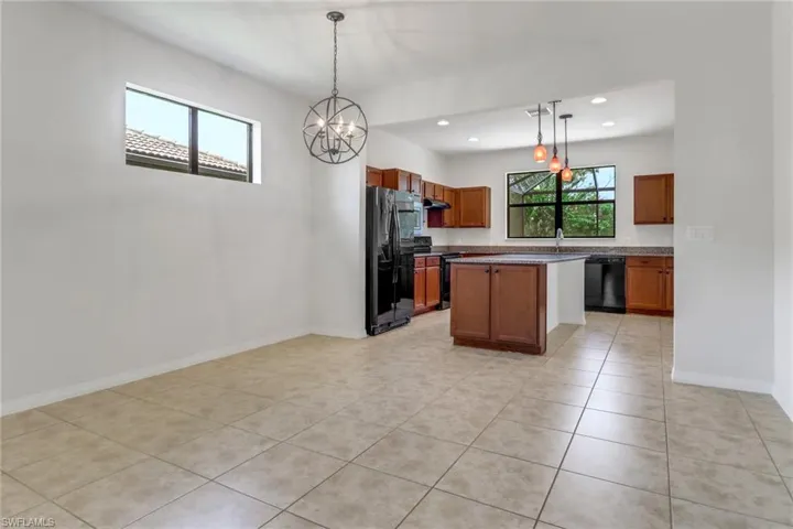 Kitchen featuring black appliances, a chandelier, light tile patterned floors, recessed lighting, and pendant lighting