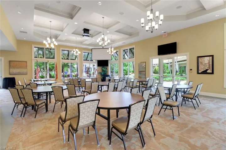 Dining space with a chandelier, coffered ceiling, a high ceiling, beamed ceiling, and recessed lighting