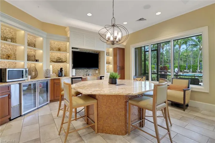 Dining space featuring a chandelier, ornamental molding, recessed lighting, wine cooler, and light tile patterned floors