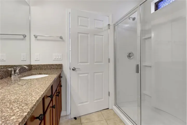 Bathroom featuring a stall shower, vanity, and tile patterned floors