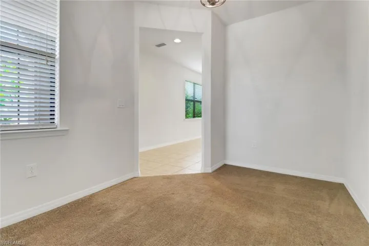 Empty room featuring light colored carpet and baseboards