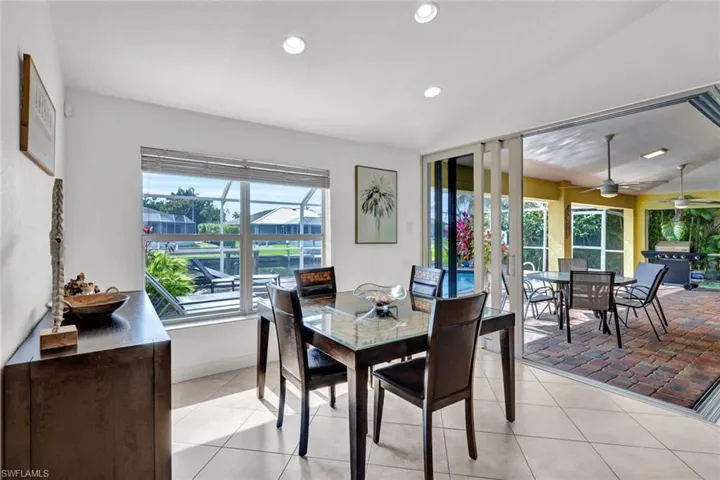 Dining area with plenty of natural light, ceiling fan, light tile floors, and lofted ceiling