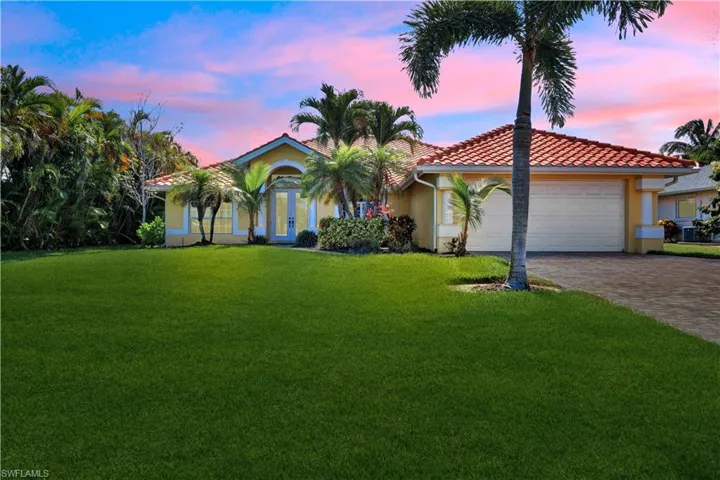 Mediterranean / spanish home with a yard and a garage
