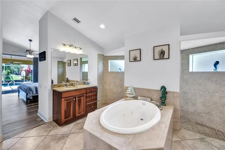 Bathroom with a healthy amount of sunlight, tile flooring, vanity, and ceiling fan