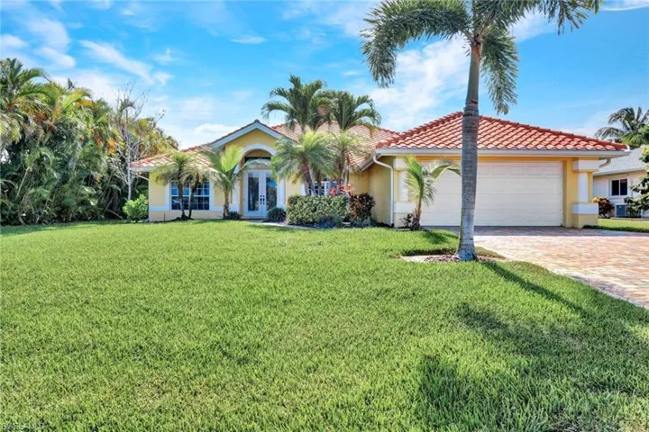 Mediterranean / spanish house with a front yard and a garage