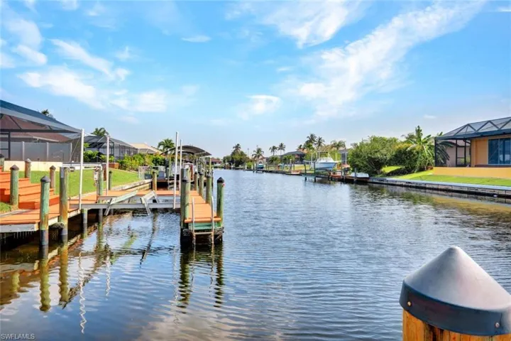 View of dock with a lanai and a water view