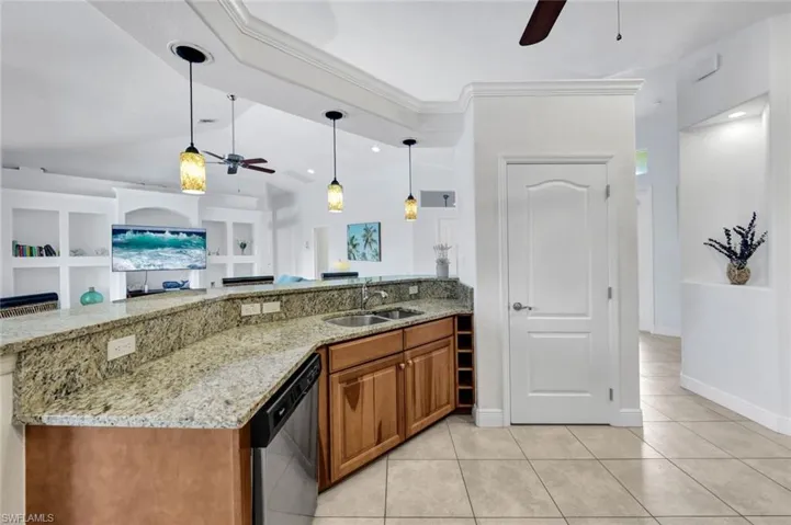 Kitchen with dishwasher, hanging light fixtures, ceiling fan, and light tile floors