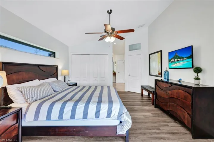 Bedroom featuring a closet, wood-type flooring, ceiling fan, and vaulted ceiling