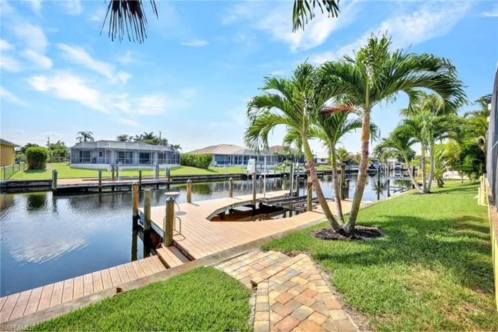 Dock area featuring a yard, a lanai, and a water view