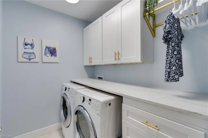 Laundry area featuring  NEW custom cabinets, folding surface, four drawers for organizing and dedicated rod to hang dry clothes.