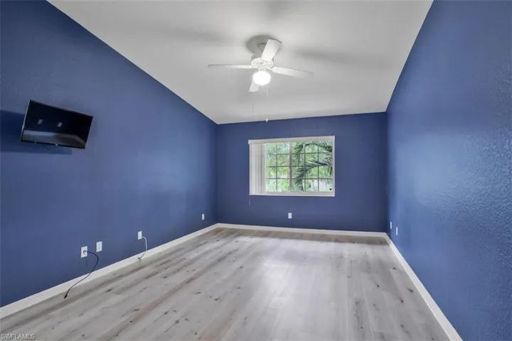 Empty room with ceiling fan and hardwood / wood-style flooring