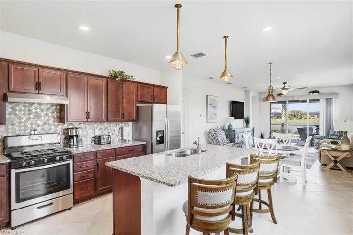 Open kitchen w/breakfast bar, granite countertops and designer backsplash.