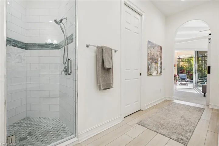Full bathroom featuring a stall shower, beam ceiling, and wood tiled floors
