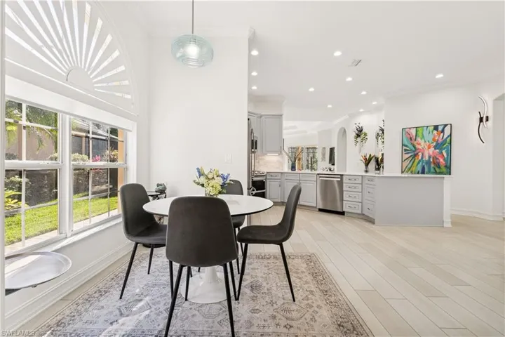 Dining area with ornamental molding, recessed lighting, and light wood finished floors
