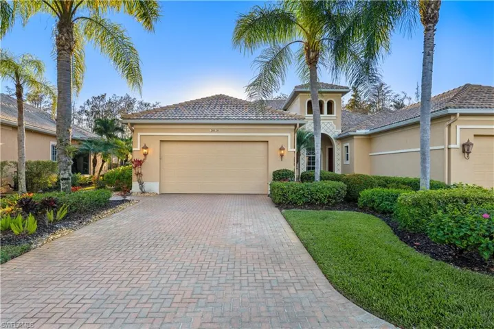 Mediterranean / spanish house with stucco siding, an attached garage, and decorative driveway
