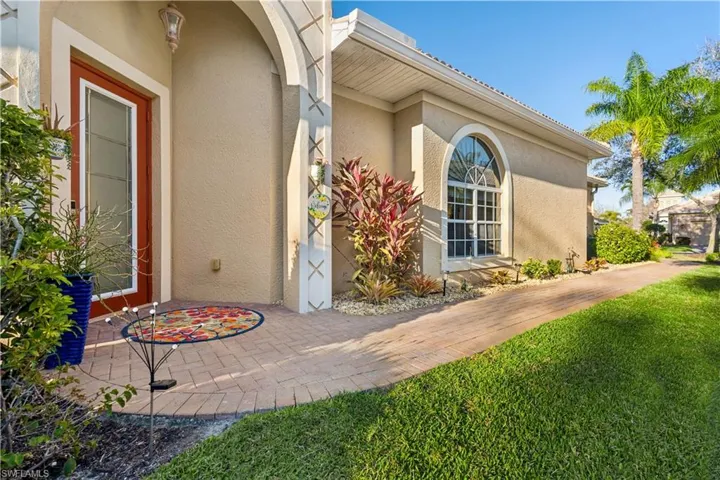 Entrance to property with a lawn and stucco siding