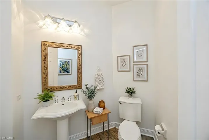Half bath featuring toilet and wood finished floors