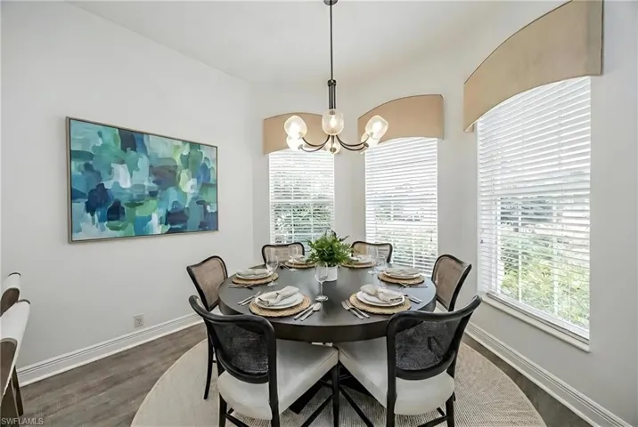 Dining room featuring suspended lighting, dark wood-style flooring, and healthy amount of natural light