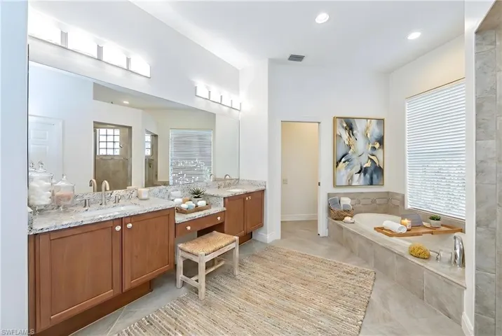 Full bath with double vanity, a tile shower, a garden tub, recessed lighting, and light tile patterned flooring