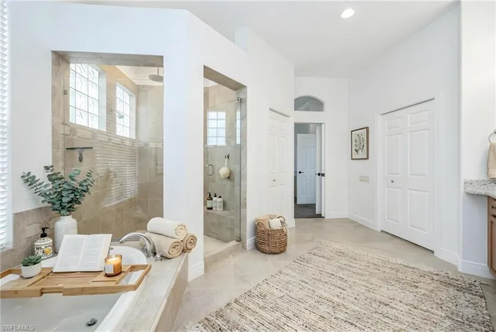 Full bath featuring a stall shower, vanity, and a bath