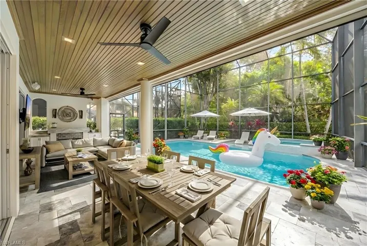Sunroom featuring a ceiling fan, an outdoor living / dining area, a pool, and a patio
