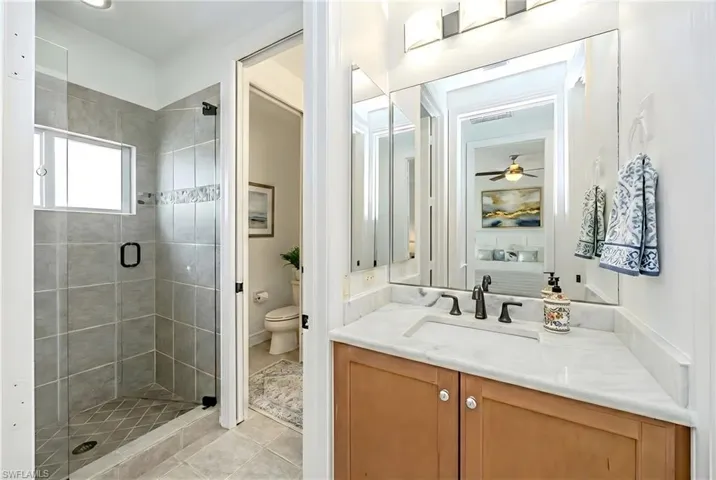 Full bath featuring vanity, a stall shower, and light tile patterned floors